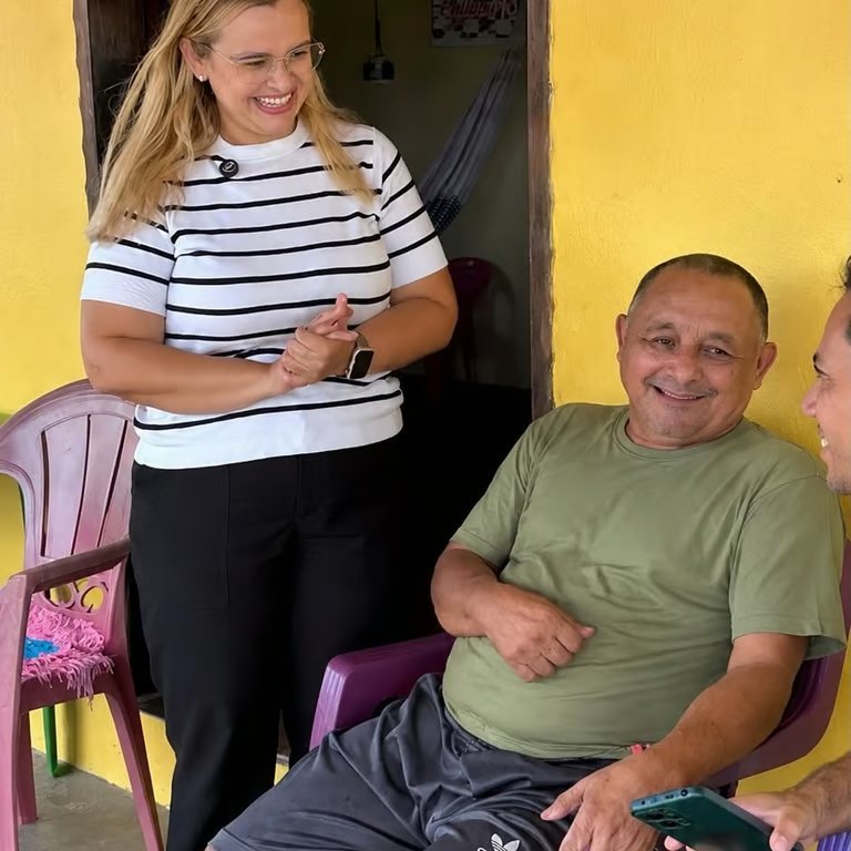 Paulinha Braga em visita domiciliar, conversando com morador na varanda de casa
